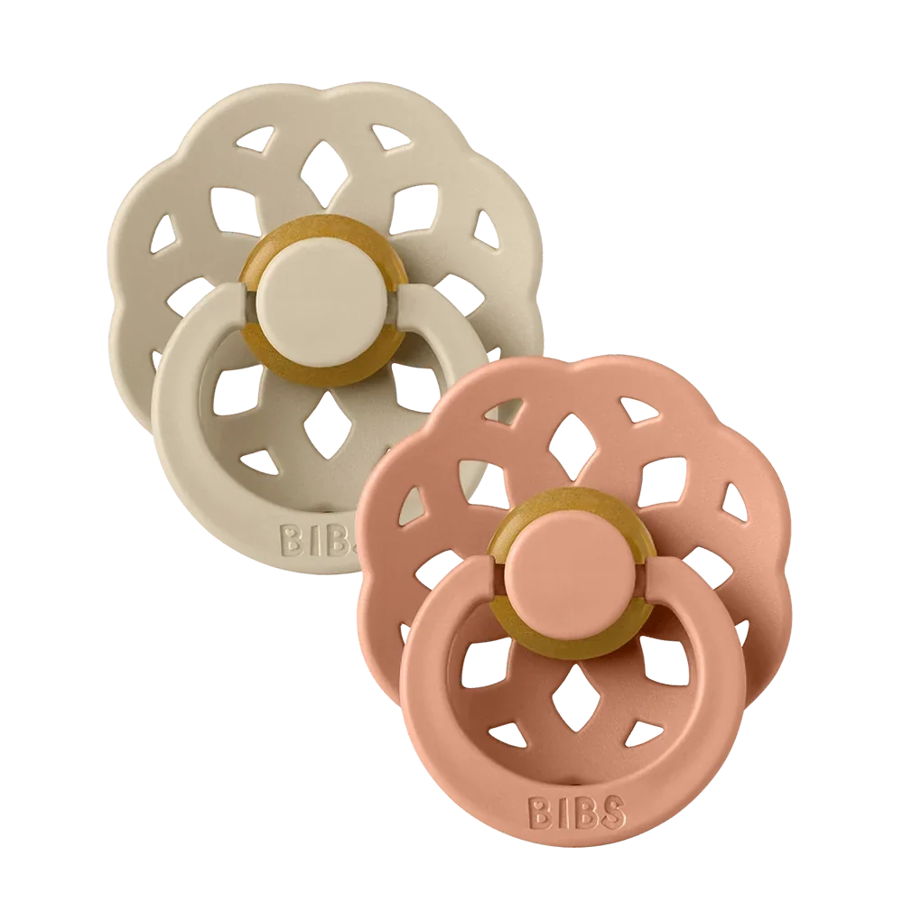 Two latex pacifiers with round vanilla and peach nipples, decorative flower shields