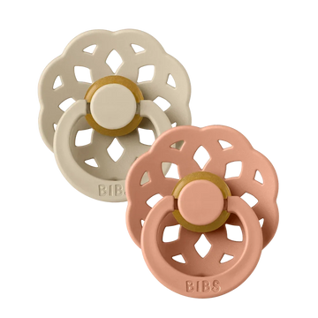 Two latex pacifiers with round vanilla and peach nipples, decorative flower shields