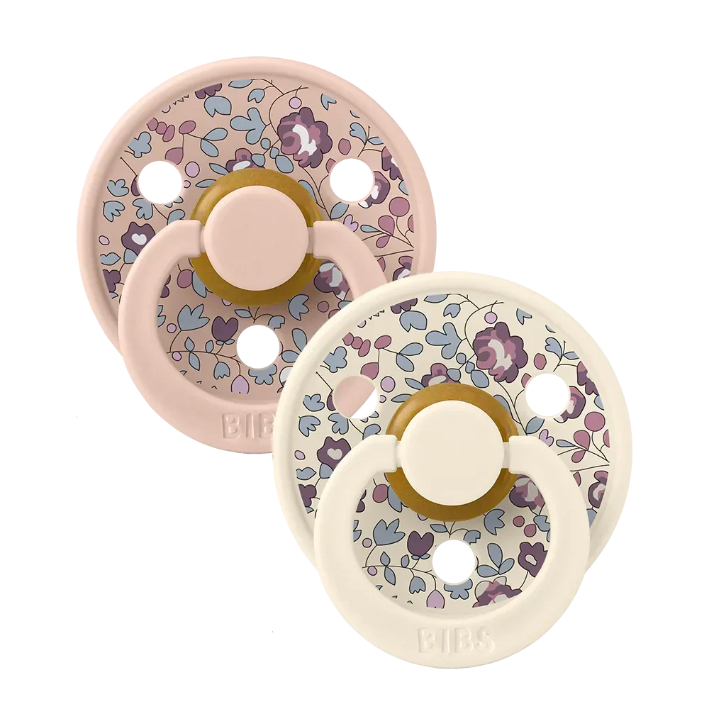Pair of blush floral latex baby pacifiers with round shields and shield loops