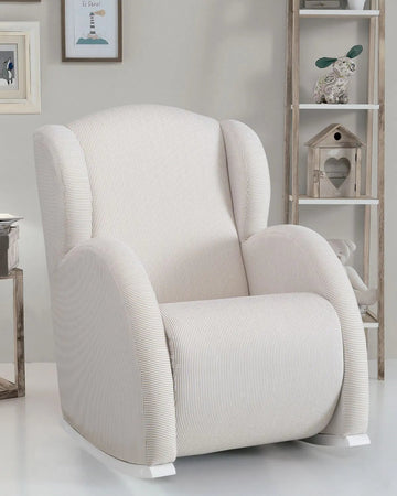 White armchair in a room with a bookshelf and decorative items.