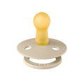 Cream pacifier with round shield, central nipple, and vent holes