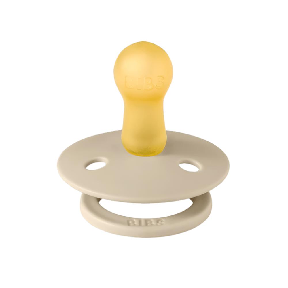 Cream pacifier with round shield, central nipple, and vent holes