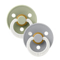 Two pacifiers with white loop handles; sage and light gray shields with warm center